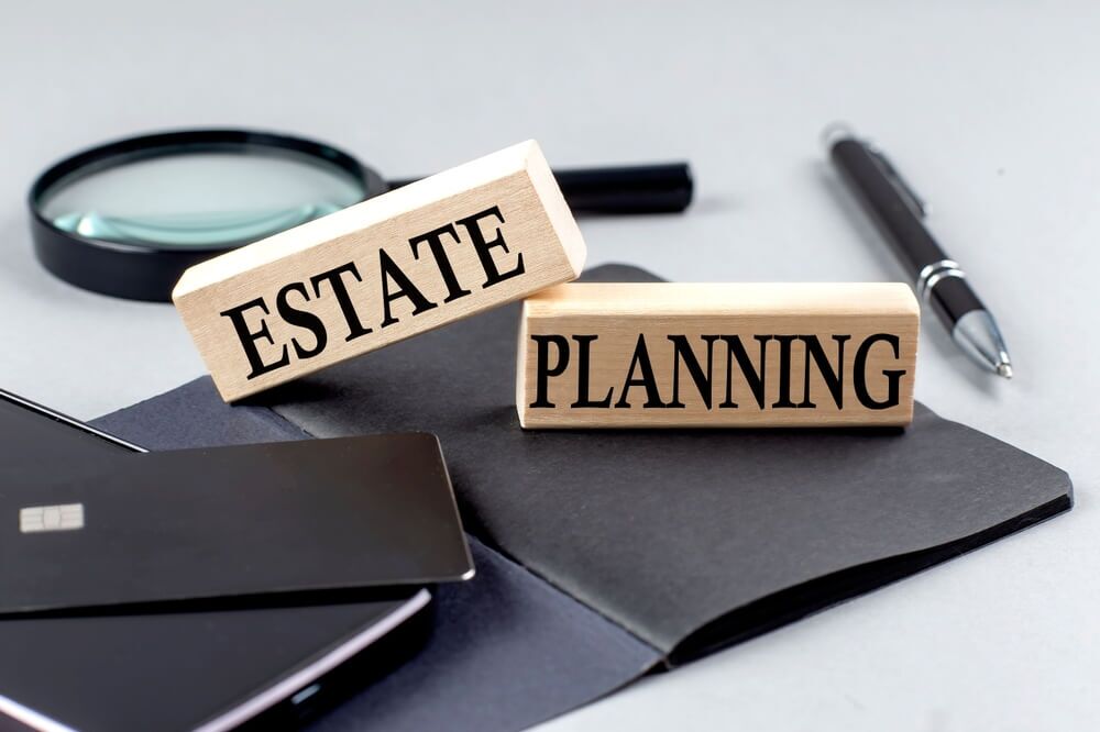 Estate planning concept with blocks labeled 'Estate' and 'Planning' on office desk — difference between making a will and estate planning